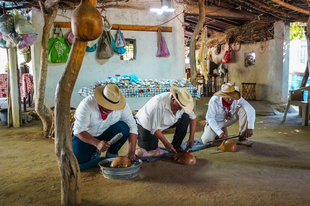 Three men skillfully crafting traditional musical instruments inside a rustic workshop, Topolobampo, Mexico.
