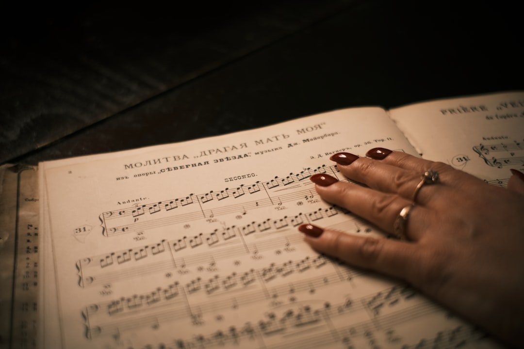 womans-hand-resting-on-sheet-music-grsbqa8qr3c